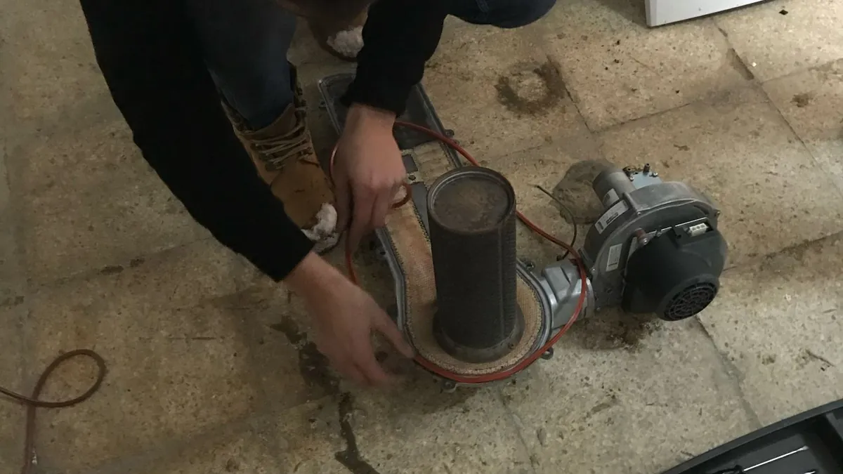 Teknisyenin kombiden sökülen brülör ve fan grubunu incelemesi